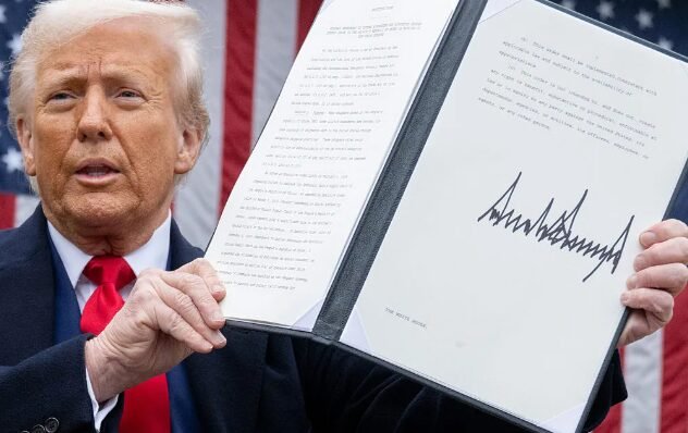Trump holding signed executive order document
