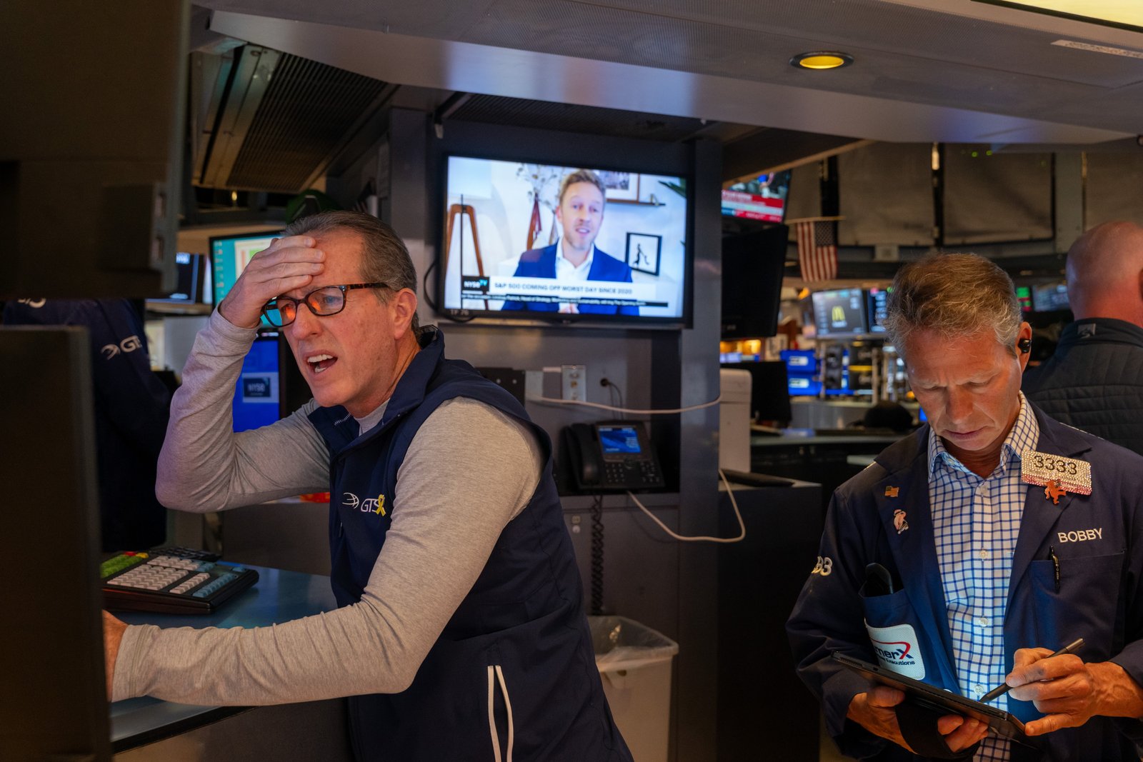 Traders work on the floor of the New York Stock Exchange Friday after the Dow dropped 1,000 points at opening